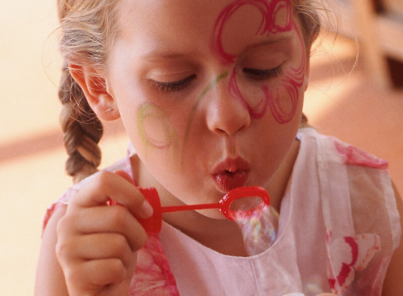 Ein kleines Mädchen bläst Seifenblasen. Ein Foto aus naher Sicht