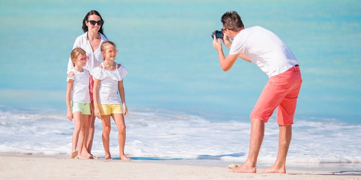 Vater fotografiert Familie am Strand